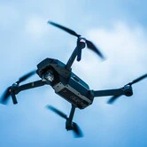 Drone quadricoptère volant dans le ciel bleu