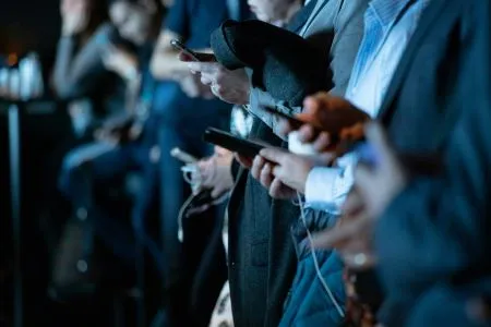 Groupe de personnes utilisant des smartphones en format portrait, illustrant l'importance du format vidéo réseaux sociaux pour l'engagement mobile.